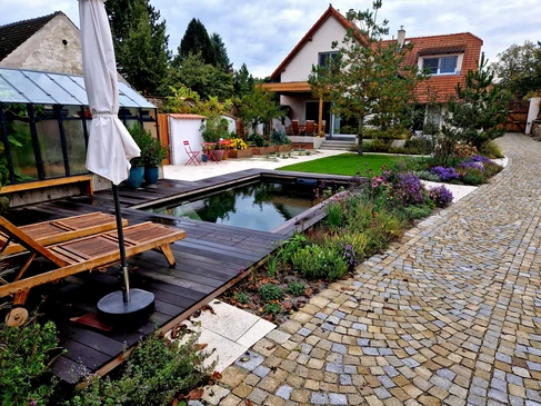 jardin familial avec piscine où l'eau est bleue et propre grâce à la composante calcaire du système de filtration