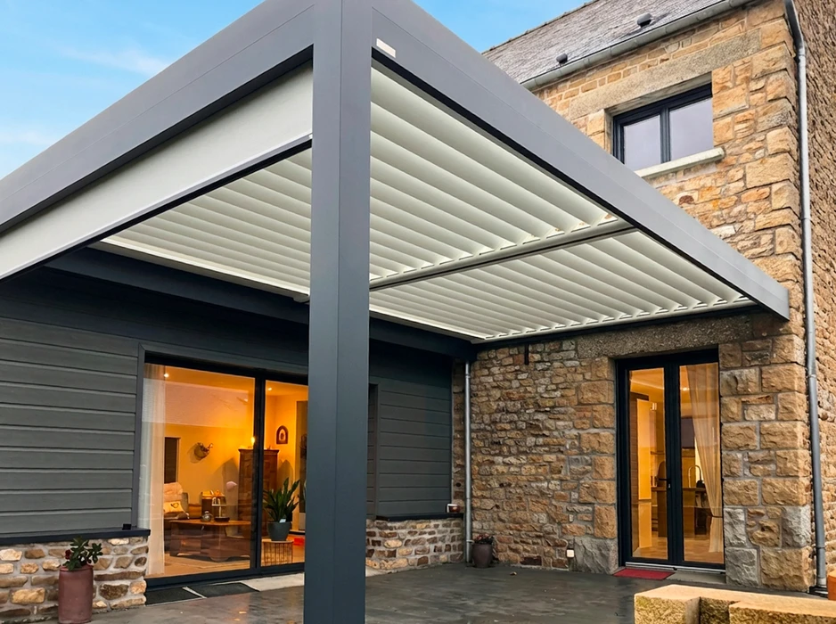 Terrasse couverte moderne adossée à une maison en pierre
