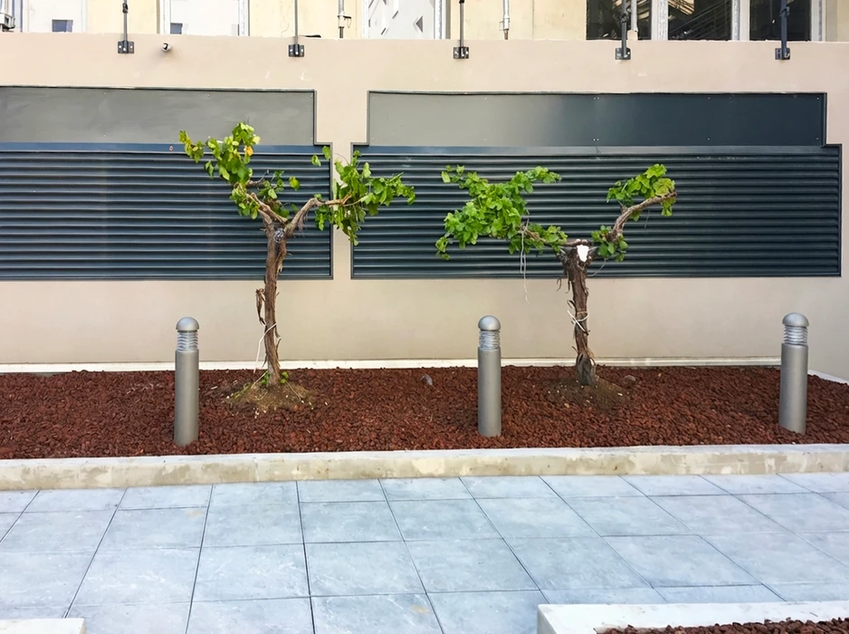 Jardin privé aménagé avec pelouse synthétique verte vive, délimité par une clôture aluminium anthracite RAL 7016 à lames horizontales avec bandeau ajouré